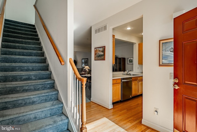 stairs featuring visible vents, wood finished floors, recessed lighting, crown molding, and baseboards