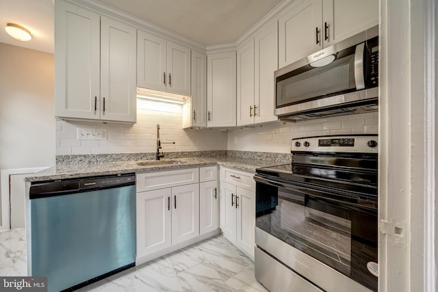 kitchen with backsplash, stainless steel appliances, marble finish floor, white cabinetry, and a sink