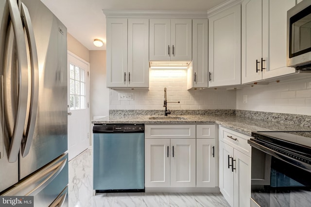 kitchen with a sink, stainless steel appliances, light stone counters, and marble finish floor