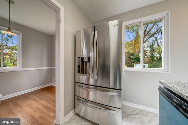 kitchen featuring dishwashing machine, baseboards, hanging light fixtures, marble finish floor, and stainless steel fridge