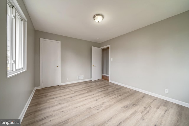 unfurnished bedroom with visible vents, baseboards, and light wood-style floors