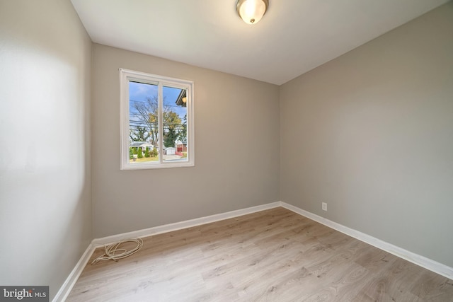 empty room with light wood finished floors and baseboards