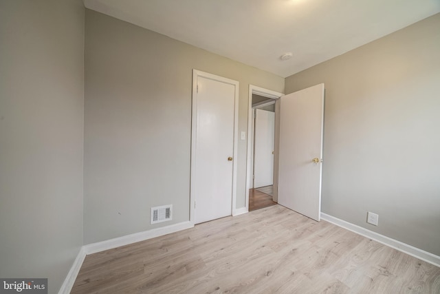 unfurnished bedroom with baseboards, visible vents, and light wood finished floors