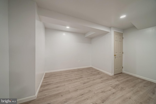 finished below grade area featuring recessed lighting, baseboards, and wood finished floors