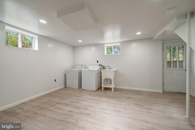 washroom featuring baseboards, washer and clothes dryer, light wood-type flooring, recessed lighting, and a sink