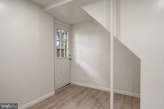 entryway with light wood finished floors and baseboards