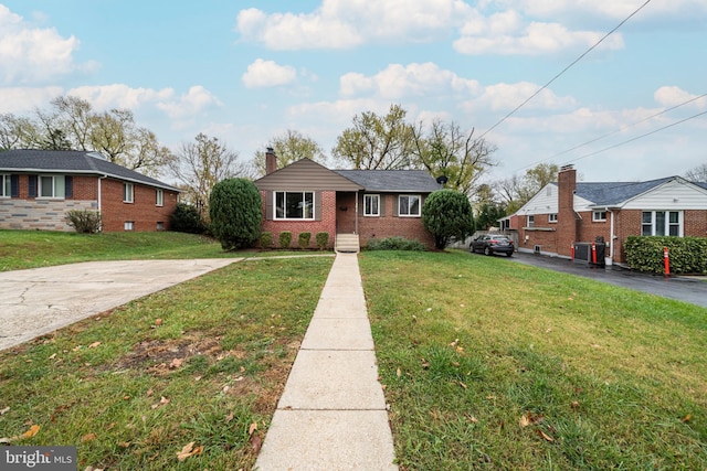 view of front of house with brick siding, driveway, a chimney, and a front lawn