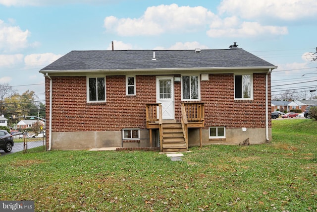 back of house with fence, a lawn, brick siding, and roof with shingles