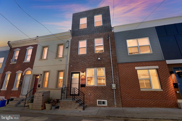 townhome / multi-family property featuring brick siding and entry steps