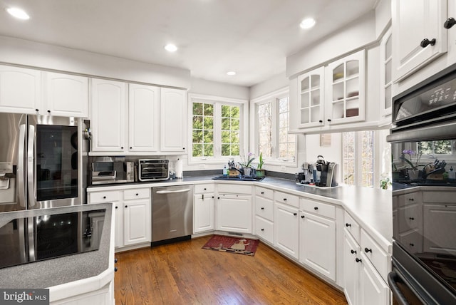 kitchen featuring black appliances, white cabinets, and wood finished floors