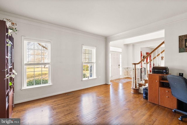 home office with baseboards, wood finished floors, visible vents, and ornamental molding