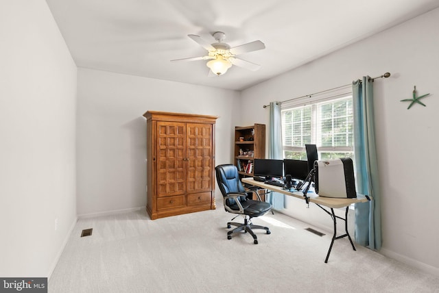 carpeted office with visible vents, baseboards, and ceiling fan