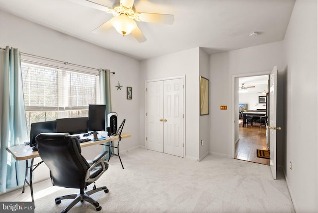 office area with baseboards, light carpet, visible vents, and ceiling fan