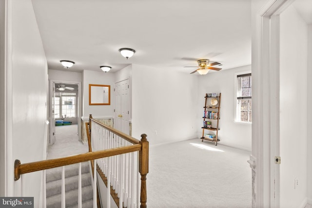 hallway featuring an upstairs landing and carpet