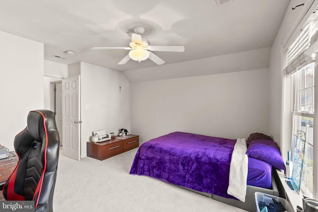 carpeted bedroom with visible vents, ceiling fan, and vaulted ceiling