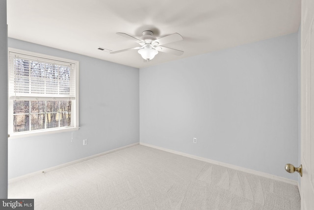 carpeted empty room featuring visible vents, baseboards, and a ceiling fan