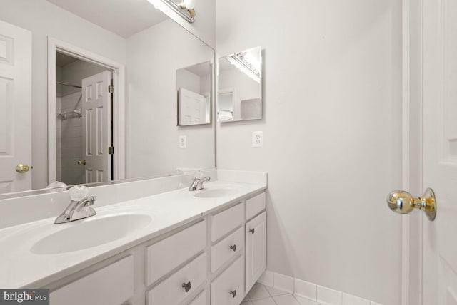 bathroom with tile patterned floors, walk in shower, double vanity, and a sink