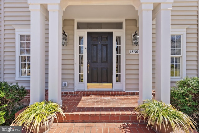 view of exterior entry with brick siding