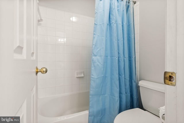 bathroom featuring shower / tub combo with curtain and toilet