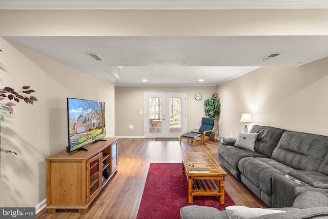 living room featuring wood finished floors, visible vents, baseboards, french doors, and crown molding