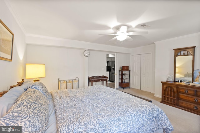 carpeted bedroom featuring visible vents, ornamental molding, black fridge, a closet, and a ceiling fan