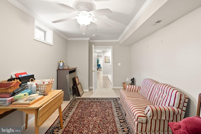 sitting room featuring visible vents, crown molding, baseboards, light colored carpet, and ceiling fan