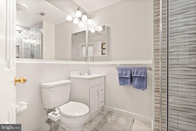 bathroom featuring a wainscoted wall, marble finish floor, toilet, and vanity