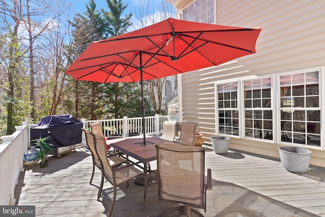 wooden terrace with outdoor dining space and grilling area