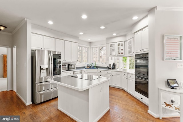 kitchen featuring recessed lighting, black appliances, white cabinets, and light wood finished floors