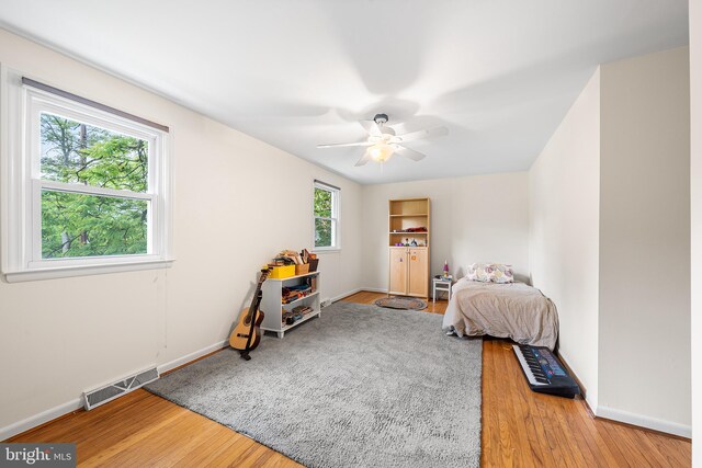 bedroom with wood finished floors, baseboards, and ceiling fan
