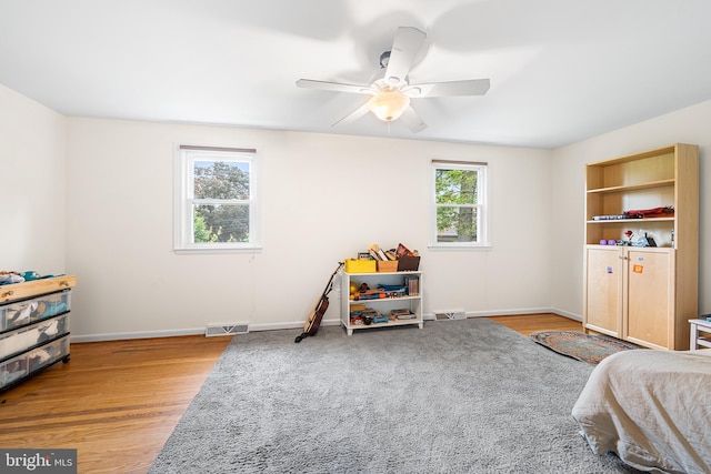 bedroom featuring wood finished floors, baseboards, and ceiling fan