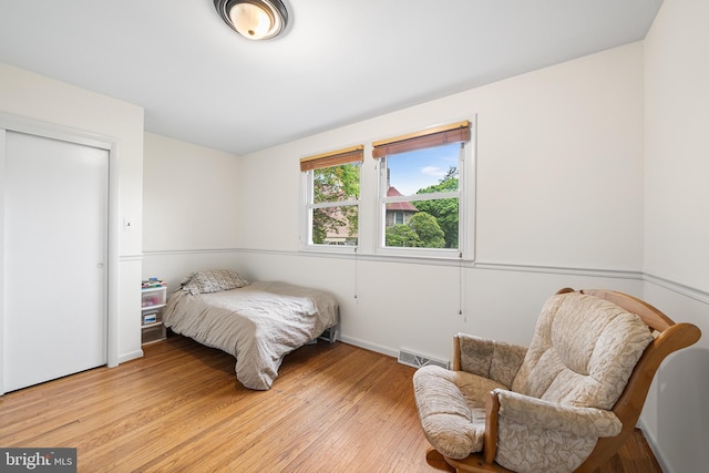 bedroom with light wood-type flooring and baseboards