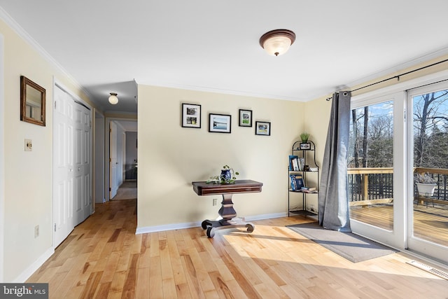 interior space with ornamental molding, baseboards, and hardwood / wood-style flooring