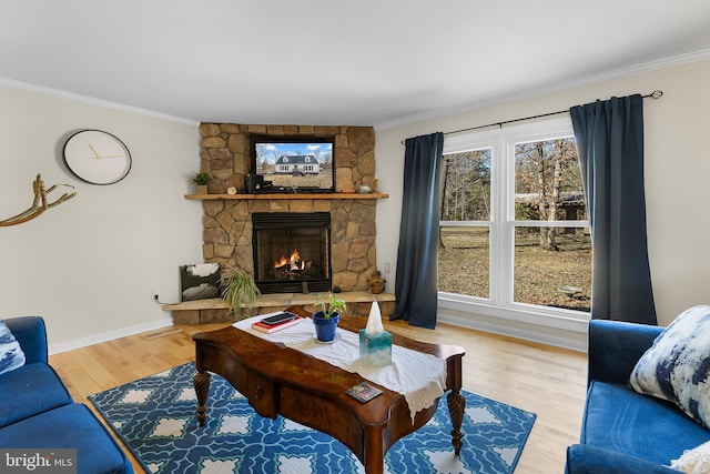 living area with wood finished floors, a fireplace, and ornamental molding