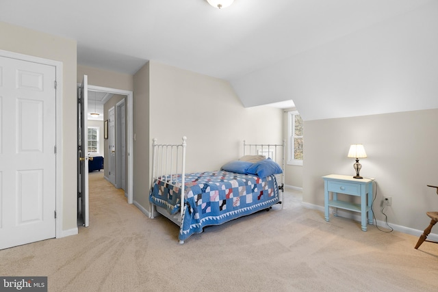 bedroom featuring baseboards, lofted ceiling, carpet, and attic access