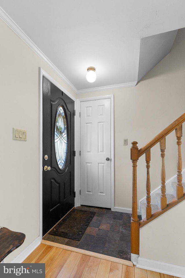 entryway featuring stairway, wood finished floors, baseboards, and ornamental molding