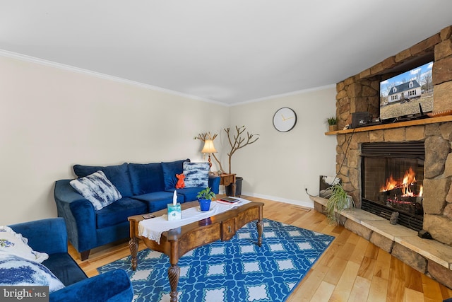 living room featuring ornamental molding, a fireplace, baseboards, and wood finished floors