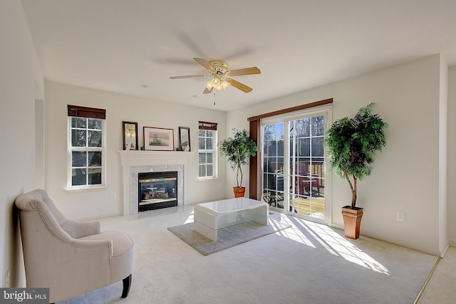 living area with a high end fireplace, carpet flooring, and plenty of natural light