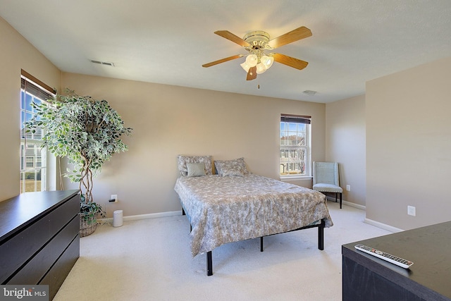 bedroom with visible vents, light carpet, baseboards, and ceiling fan