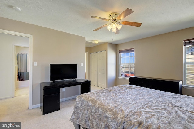 bedroom with a ceiling fan, baseboards, a closet, a textured ceiling, and carpet flooring