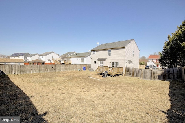 view of yard with a wooden deck, a residential view, and a fenced backyard