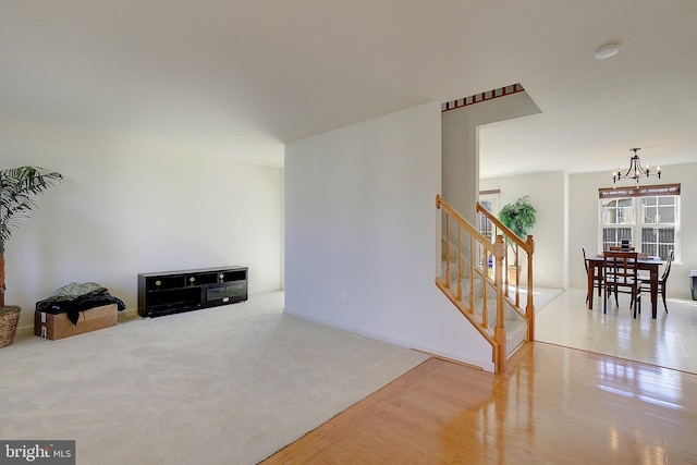 interior space featuring an inviting chandelier, stairway, wood finished floors, and carpet floors