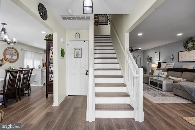 stairs with visible vents, ceiling fan with notable chandelier, wood finished floors, recessed lighting, and baseboards