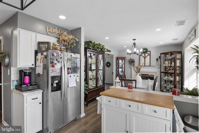 kitchen featuring butcher block countertops, visible vents, white cabinetry, and stainless steel fridge with ice dispenser