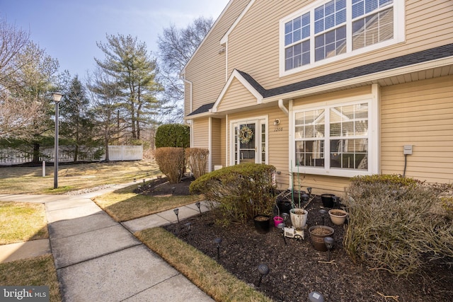 doorway to property featuring a shingled roof