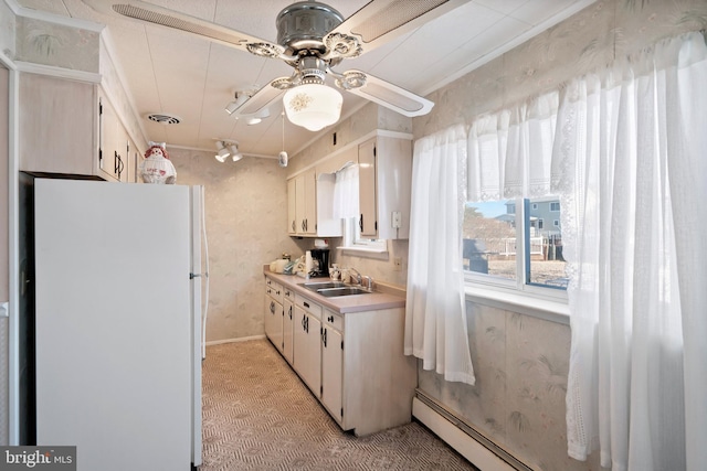 kitchen with visible vents, a sink, freestanding refrigerator, light countertops, and baseboard heating