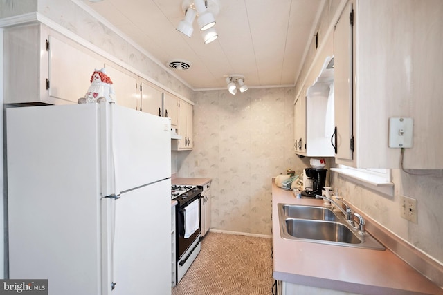 kitchen with visible vents, a sink, freestanding refrigerator, gas stove, and wallpapered walls