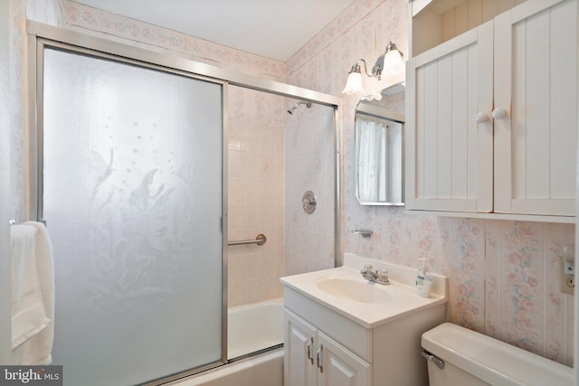 full bathroom with wallpapered walls, toilet, vanity, and shower / bath combination with glass door