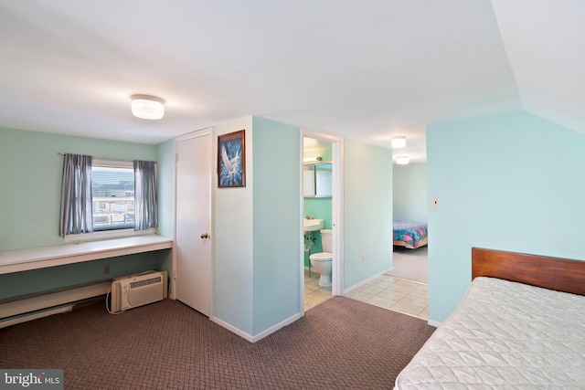 carpeted bedroom featuring baseboards, lofted ceiling, tile patterned flooring, ensuite bathroom, and a wall mounted air conditioner