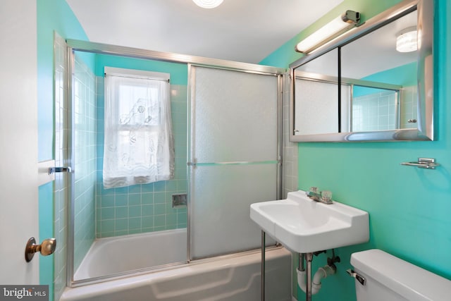 bathroom with a sink, toilet, and enclosed tub / shower combo